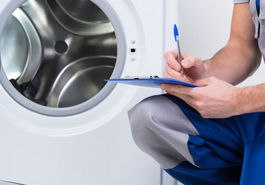 many holding a pen and paper beside a washing machine